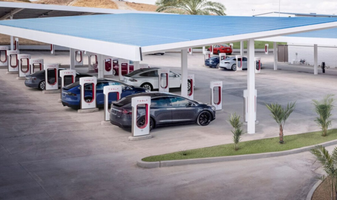 Tesla Supercharger station med flere Tesla-biler under opladning.