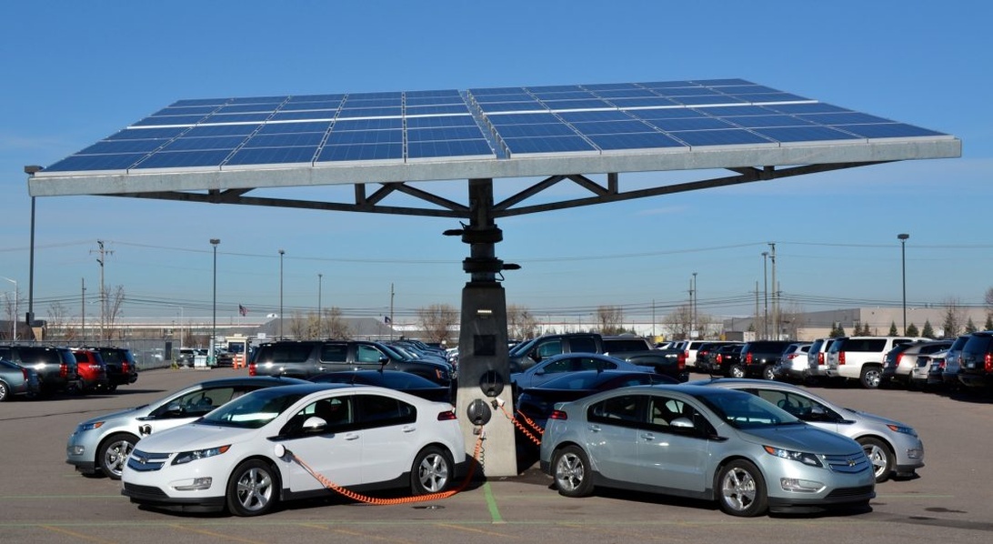 Elbiler oplader ved en solcelledrevet ladestation.